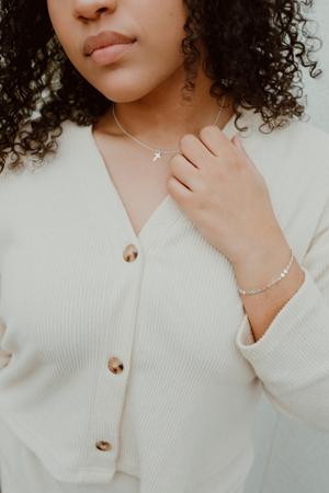 Image of model wearing cross jewelry that is a perfect gift for daughter